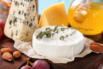 Cheese, honey and fruit on a table. Selective focus. Copy space.