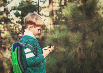little boy travels with compass in forest © nadezhda1906