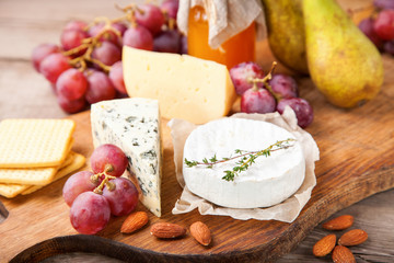 Cheese, honey and fruit on a table. Selective focus.  Copy space.