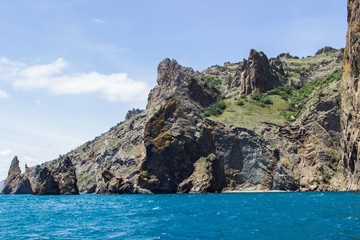 Fototapeta na wymiar Rocky coastline of south Crimea. View from the sea: golden gates of Karadag