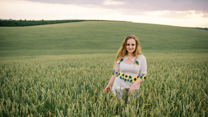 Young girl at ukrainian national dress posed at wreath field.