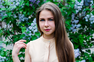 Fototapeta premium Pretty girl with posing at garden against blooming lilac.
