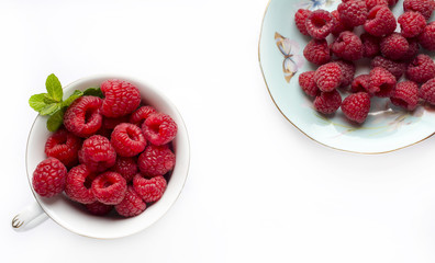 Fresh raspberries in a cup on white background
