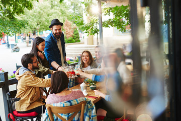 Obraz premium Group of young friends cheering up with drinks