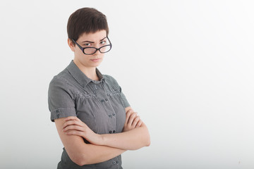 Portrait of beautiful young business woman or angry female teacher accusingly frowning over her glasses