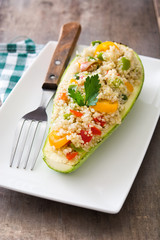 Stuffed zucchini with quinoa and vegetables on wooden background
