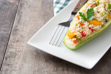 Stuffed zucchini with quinoa and vegetables on wooden background
