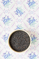 Belugalinsen in einer Schüssel auf einer geblümten Tischdecke