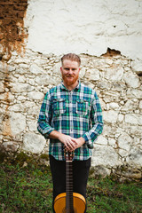 Hipster man with red beard with a guitar