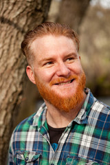 Portrait of red haired man with long beard in the forest