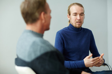 Young man sharing his trouble with psychotherapist