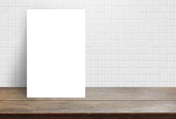 Blank White paper poster on wood table top at white ceramic tile wall,Template mock up for adding your design.