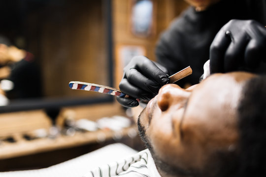 Barber shaving face of his client