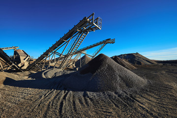 Industrial background with gravel crusher. Extraction of gravel. Conveyor for transporting gravel....