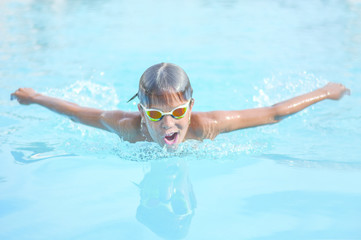 Close up action shot of boy swimming butterfly