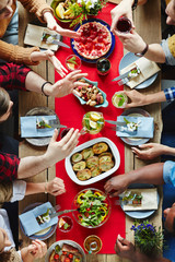 Group of friends talking by served festive table