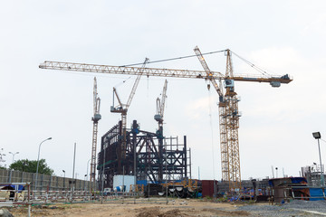 Fototapeta na wymiar Construction site with three working tower cranes background