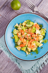 Shrimp, Avocado, Apple and Onion Salad. Grilled prawns on blue plate. View from above, top studio shot