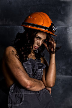 Close-up Portrait Sexy Female Miner Worker In Coveralls Over His Naked Body, Helmet On The Head With A Flashlight