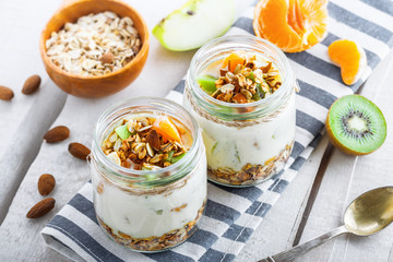 Granola with yogurt and fruits in a rustic jar. Delicious healthy American food for breakfast. Traditional US snack. Top view.