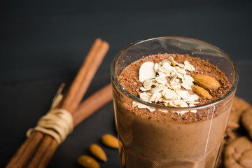 Chocolate smoothie with bananas and cookies on the dark wooden background