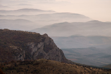 Panoramic view to the mountain ridge at the seaside of Black sea. Layer of mountains and mist at sunrise time, Crimea, Russia