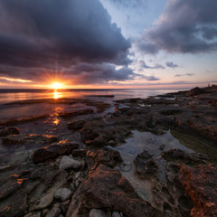 One vivid autumn sunset over curved crevices in the limestone on the shore of Khersones cape, Crimea