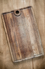 Fototapeta premium Rustic Wooden Cutting Board on Wooden Background.