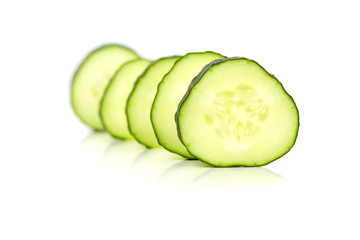Cucumber slices line up, over a white background.