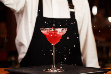 Barman in making cocktail at a nightclub. Nightlife concept. No face. Pouring into glass