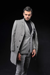 businessman posing with gray suit on black background