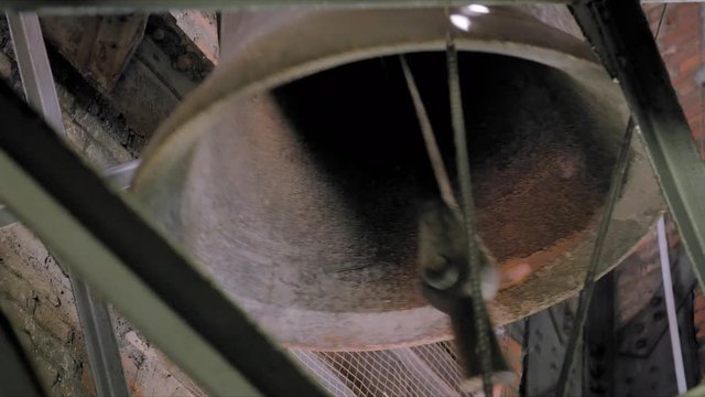 In an Old Church Belfry a Bell Ceases Ringing, The belfry is made with bricks and steel. 