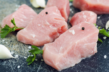 Raw Meat With Spices And Garlic Closeup On Scractched Board