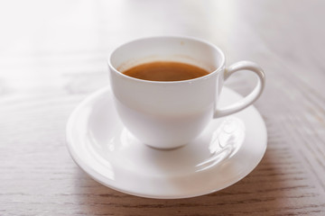 hot coffee in white cup on vintage wooden table