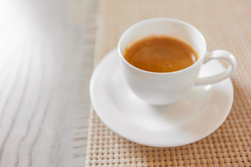 hot coffee in white cup on vintage wooden table