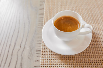 hot coffee in white cup on vintage wooden table