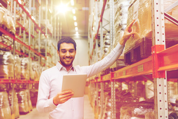 happy businessman with tablet pc at warehouse