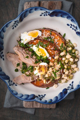 Baked pumpkin with chicken and eggs on the wooden background top view