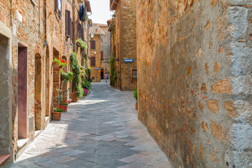 Beautiful narrow alley with traditional historic houses at Pienza city