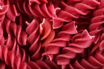 Background of colorful pasta texture close-up. Assortment of colorful macaroni. italian pasta. Variety of types and shapes of dry Italian pasta. Full background of dry uncooked macaroni.