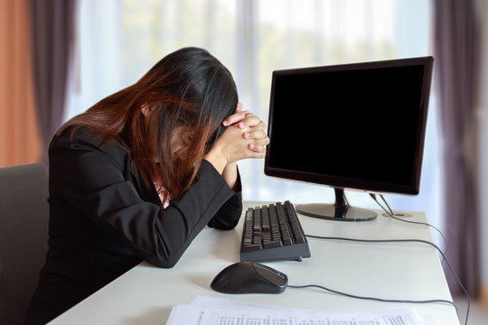 Stressed or headache business woman at office desk - failure business concept.