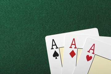Three aces on the green table of a casino. Poker.