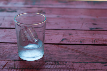 glass of ice on a wooden table