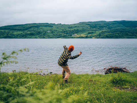 Unrecognizable person throwing stone in water