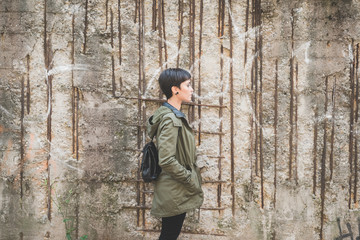 Young beautiful caucasian short hair woman posing from the side outdoor in the city