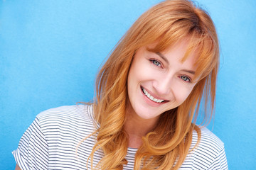 attractive redhead woman laughing by blue wall