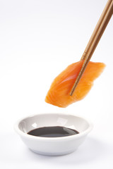 Salmon sushi nigiri with chopsticks on white background