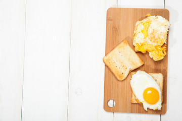 Toasts and egg on a white wooden table