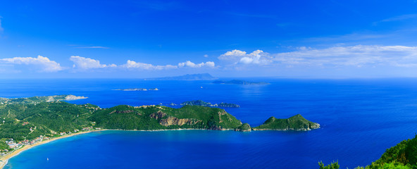 Beautiful summertime panoramic seascape. View of the cliff into the crystal clear azure sea bay and distant islands. Agios Stefanos cape. Afionas. Corfu. Greece.