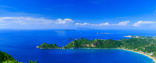 Beautiful summertime panoramic seascape. View of the cliff into the crystal clear azure sea bay and distant islands. Agios Stefanos cape. Afionas. Corfu. Greece.